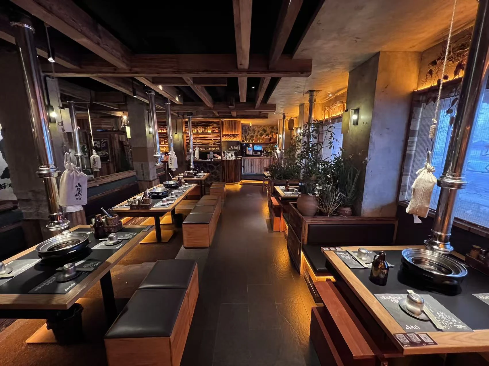 山与山肉铺丹东店实景，展示木材、岩石与就餐空间